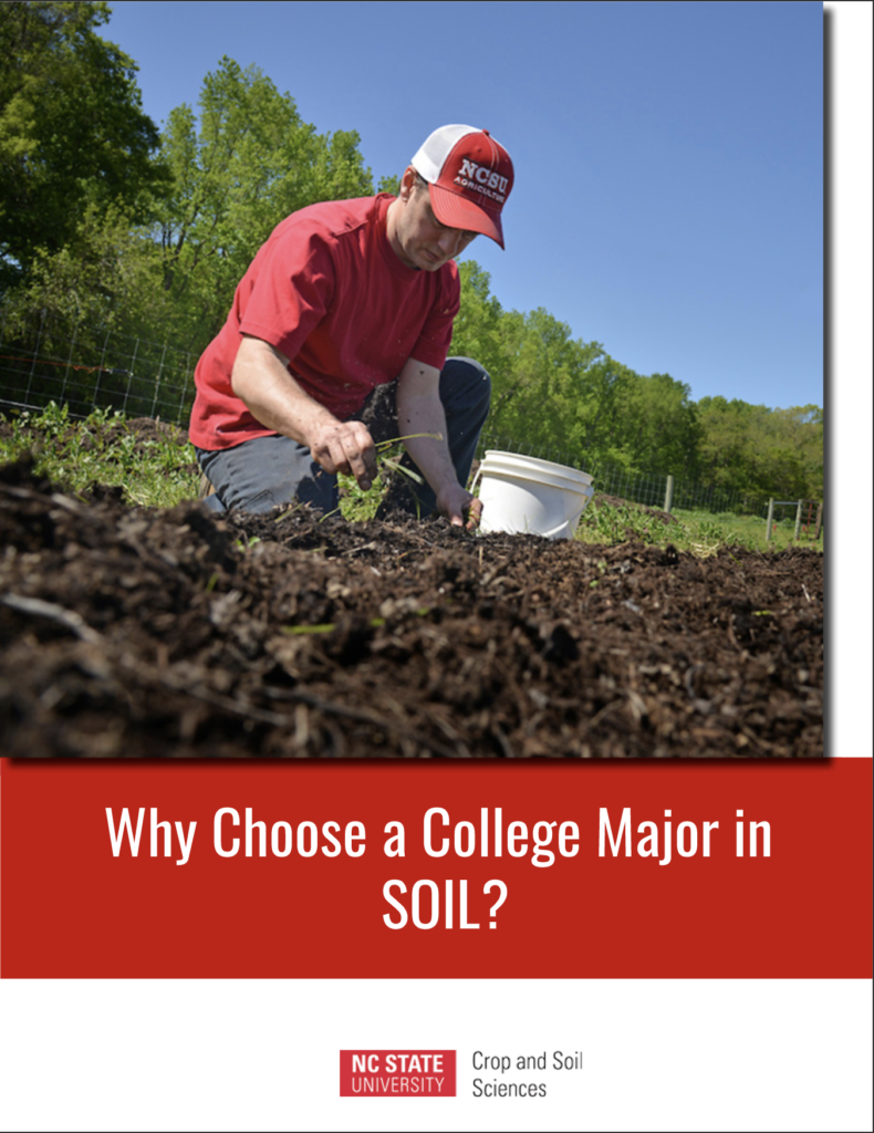 man in red shirt digging in soil